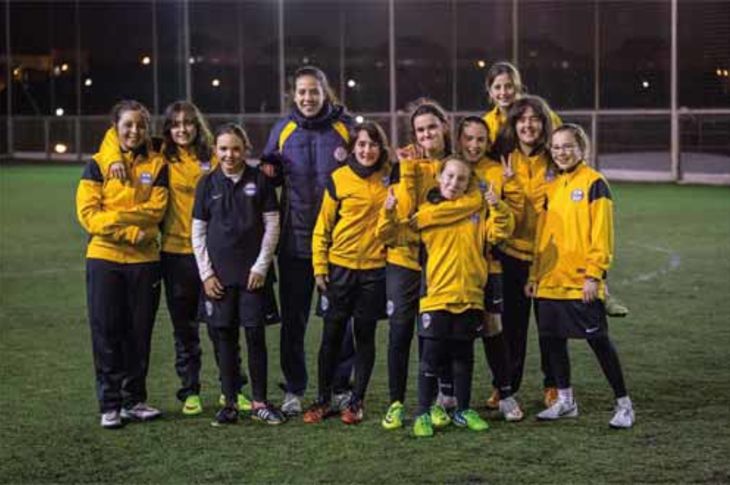 Diez de las doce jugadoras que forman el equipo femenino del Club de Fútbol Nuevo Boadilla, con su entrenadora, Paula.