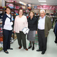 De izquierda a derecha: Alicia González, Matilde Márquez, Rosa García y el párroco de la iglesia de las Lomas, Francisco Lage, en las nuevas instalaciones que ocupa el ropero.