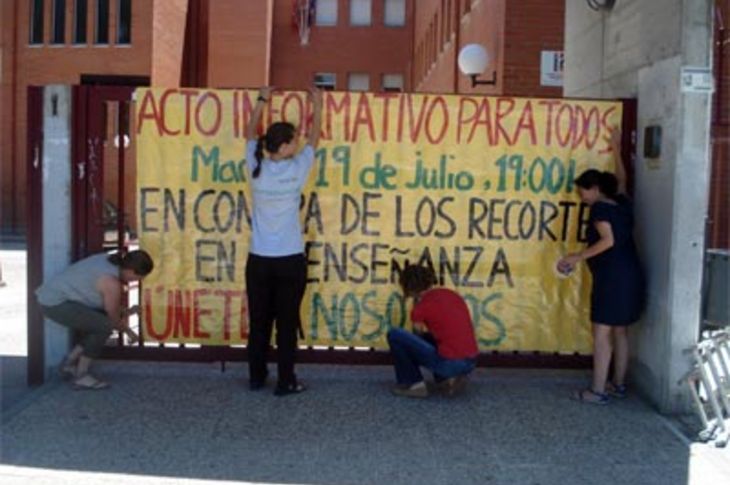 Convocantes de la concentración de mañana martes, en el Instituto Profesor Máximo Trueba de Boadilla del Monte, contra los recortes educativos, colocan en el centro el cartel de la misma.