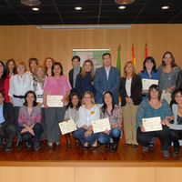 Foto de familia de las 14 participantes en el curso, ya con sus diplomas, junto a distintos miembros de la corporación municipal, el alcalde entre ellos.