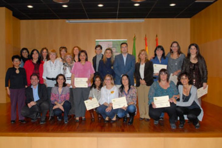 Foto de familia de las 14 participantes en el curso, ya con sus diplomas, junto a distintos miembros de la corporación municipal, el alcalde entre ellos.